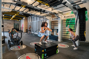 Resort fitness center with guests doing strength training, functional workouts, and group exercise indoors Resort fitness center with guests doing strength training, functional workouts, and group exercise indoors