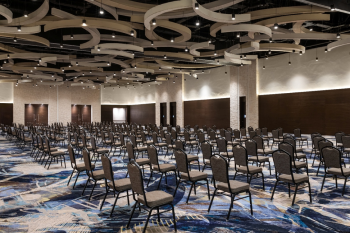Large indoor ballroom with rows of chairs, contemporary ceiling design, and event setup for weddings or receptions Large indoor ballroom with rows of chairs, contemporary ceiling design, and event setup for weddings or receptions