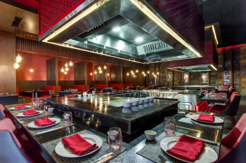 Zen Asian Cuisine at Royalton Bavaro features a teppanyaki-style dining setup with a central grill and stylish place settings—perfect for group dinners during your destination wedding Zen Asian Cuisine at Royalton Bavaro features a teppanyaki-style dining setup with a central grill and stylish place settings—perfect for group dinners during your destination wedding