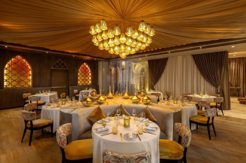 Elegant Lebanese restaurant interior with warm lighting and round dining tables at Moon Palace The Grand – Cancun.