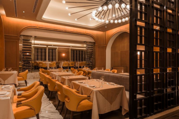 Upscale French restaurant with elegant seating, wine display, and chandelier lighting at Moon Palace The Grand – Cancun.