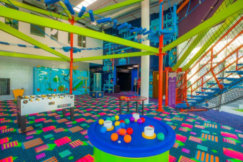 Indoor play center with climbing structures, games, and colorful activity areas for kids and teens.