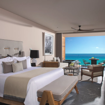 Luxury junior suite at Secrets Moxché with king bed, modern furnishings, and private ocean-view balcony