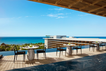 Observatory rooftop terrace at Secrets Moxché with panoramic ocean views, cocktail tables and Caribbean backdrop