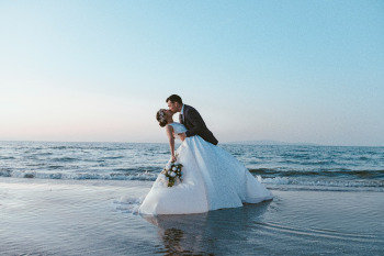 Bride and groom sharing a kiss on the beach during a Riviera Maya destination wedding