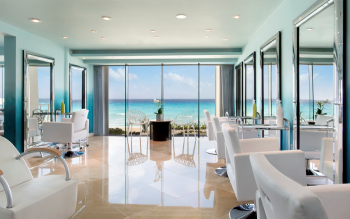 Oceanview beauty salon with styling chairs and floor-to-ceiling windows overlooking the beach
