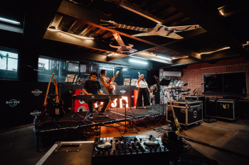 Guests performing with instruments on stage at the Music Lab experience inside the resort