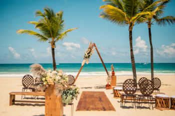 Beach wedding ceremony setup with wooden arch and pampas florals for Free Spirit package