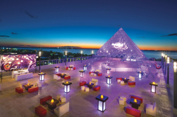 Sunset Terrace wedding venue with illuminated setup and ocean views at dusk