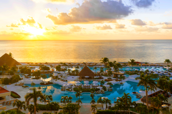 Sunset aerial view of oceanfront pools, palm-lined walkways, and beachfront resort spaces at the Sunrise section of Moon Palace. Sunset aerial view of oceanfront pools, palm-lined walkways, and beachfront resort spaces at the Sunrise section of Moon Palace.