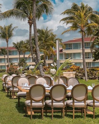 Outdoor reception setup at Chapel Garden venue at Moon Palace Cancun surrounded by palm trees and tropical landscaping. Outdoor reception setup at Chapel Garden venue at Moon Palace Cancun surrounded by palm trees and tropical landscaping.