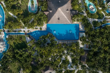 Aerial view of El Dorado Royale showcasing
tropical grounds, interconnected pathways, pools, and event spaces used for
destination wedding celebrations. Aerial view of El Dorado Royale showcasing
tropical grounds, interconnected pathways, pools, and event spaces used for
destination wedding celebrations.