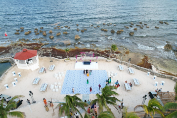Aerial view of a beachfront wedding setup
at the White Beach Gazebo featuring ceremony seating, ocean views, and event
space along the Caribbean shoreline. Aerial view of a beachfront wedding setup
at the White Beach Gazebo featuring ceremony seating, ocean views, and event
space along the Caribbean shoreline.