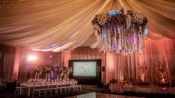 Elegant ballroom reception setup with
dramatic draping, floral installations, and formal seating for a destination
wedding celebration. Elegant ballroom reception setup with
dramatic draping, floral installations, and formal seating for a destination
wedding celebration.