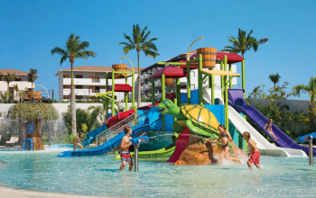 Kids playing at the turtle-themed water park with slides at Dreams Playa Mujeres