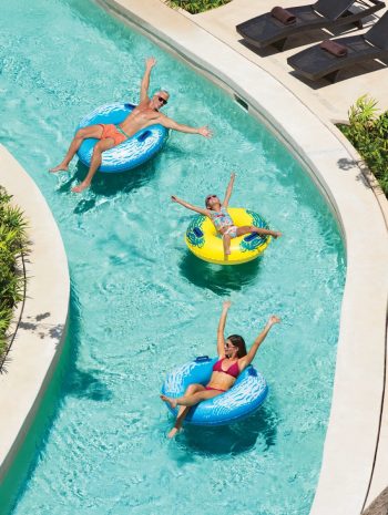 Family floating on inner tubes down the lazy river at Dreams Playa Mujeres
