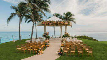 Cliff Gazebo at Hyatt Ziva Cancun set up for an oceanfront wedding ceremony with floral arch and guest seating