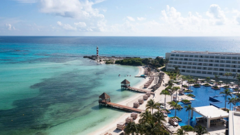 Aerial view of Hyatt Ziva Cancun's coastline with a lighthouse and turquoise Caribbean water in Cancun